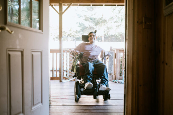 Confident Young Man In Wheelchair At Home